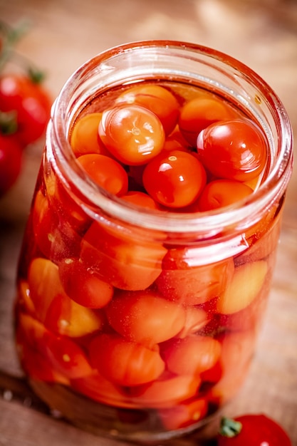 Tomates maduros en escabeche en un tarro de cristal