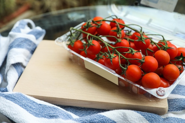 Tomates maduros frescos em recipiente na mesa fechada Espaço para texto