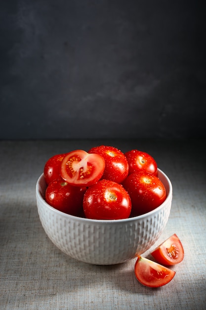 Tomates maduros frescos en un recipiente gris