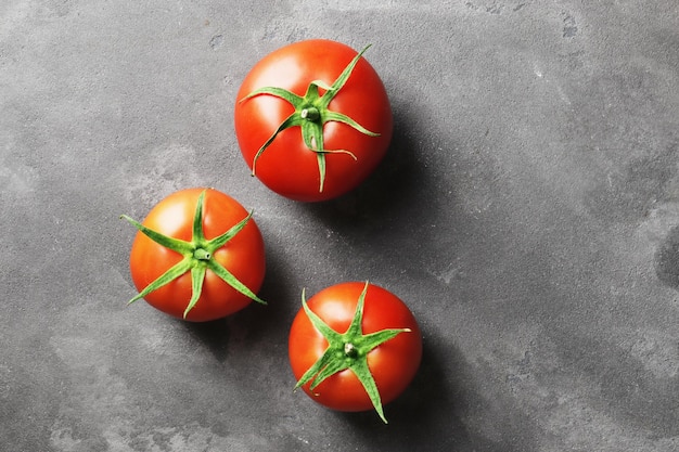 Foto tomates maduros frescos sobre un fondo de hormigón vista superior vista desde arriba