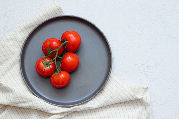 Tomates maduros en un plato negro