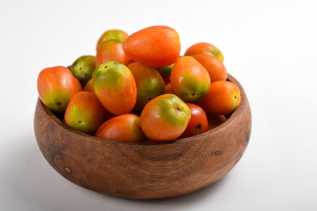 tomates maduros en un tazón aislado fondo blanco.