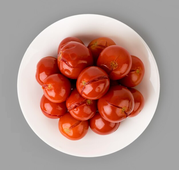 Tomates marinados en un plato aislado