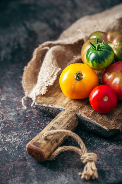 Tomates multicolores frescos y maduros sobre un fondo oscuro.