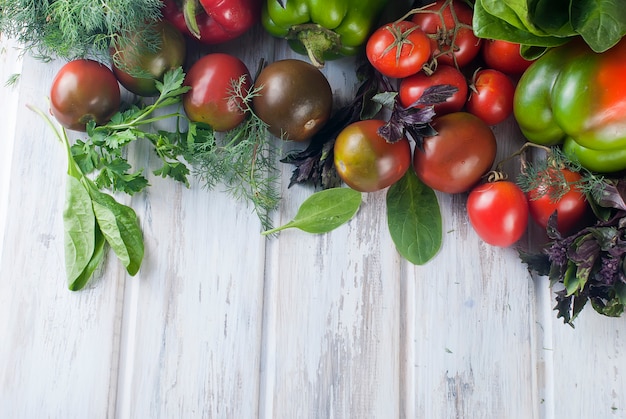 Tomates negros y rojos, pimientos verdes y rojos, hierbas.