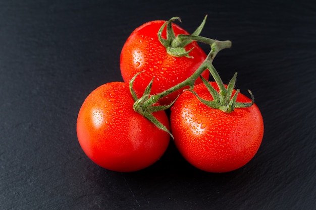 Tomates orgánicos en pizarra negra con espacio de copia