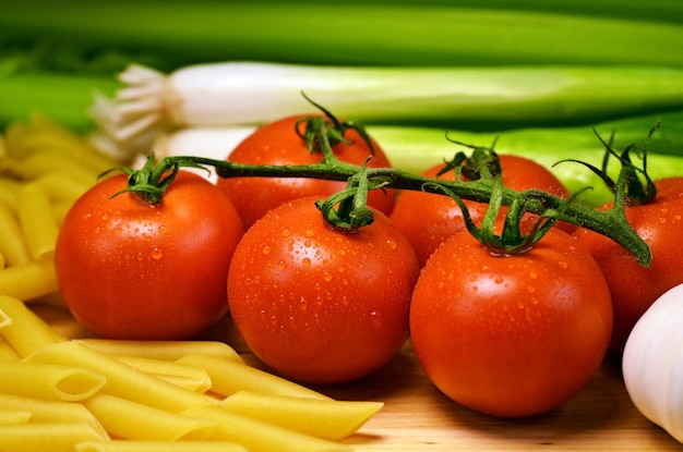 Tomates en un palo con cebollas verdes y apio