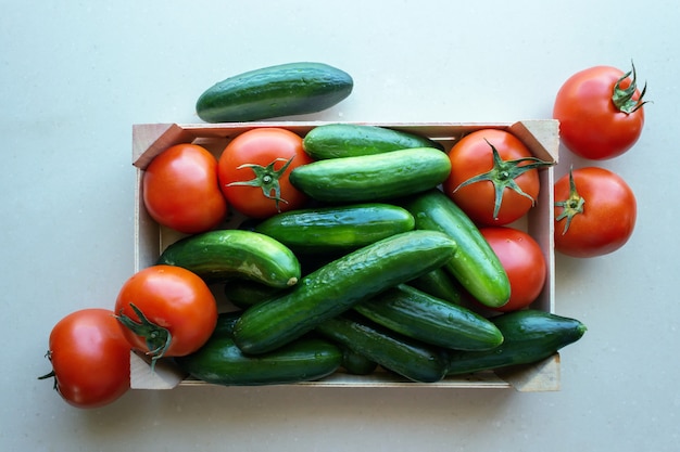 Tomates y pepinos en una caja de madera