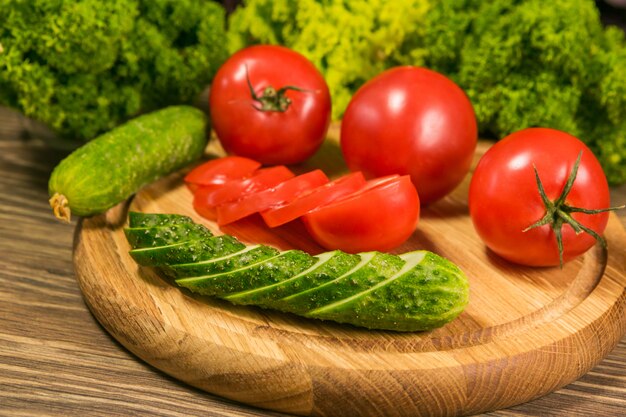 Tomates y pepinos en una mesa de madera