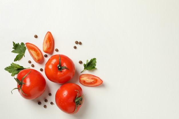 Tomates, perejil y pimiento sobre fondo blanco.