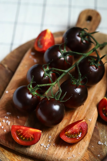 Tomates pretos com sal marinho em uma placa de madeira