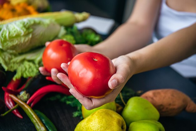 Tomates de primer plano en manos femeninas en la cocina