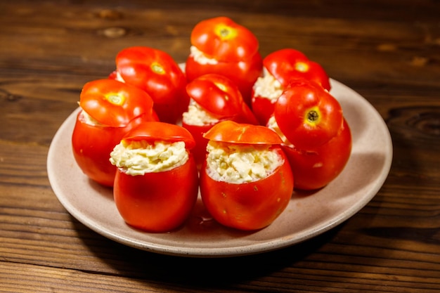 Tomates rellenos de queso en mesa de madera