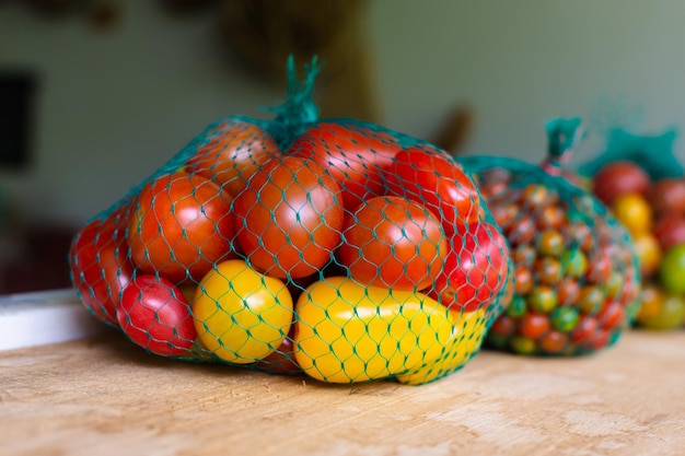 Tomates rojos y amarillos frescos en una malla en un mercado latinoamericano tradicional