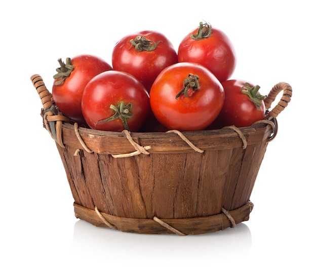 Tomates rojos en una canasta aislado en blanco