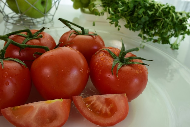 Tomates rojos frescos con gotas de agua sobre la piel del tomate. Mezclar frutas. Frutas frescas cerca de ti.