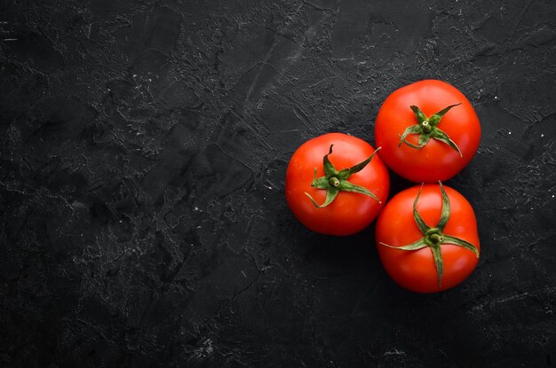 Tomates rojos frescos sobre un fondo oscuro Verduras Vista superior Espacio libre para su texto