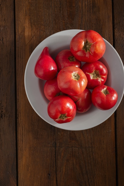 Tomates rojos frescos en una vista superior de madera