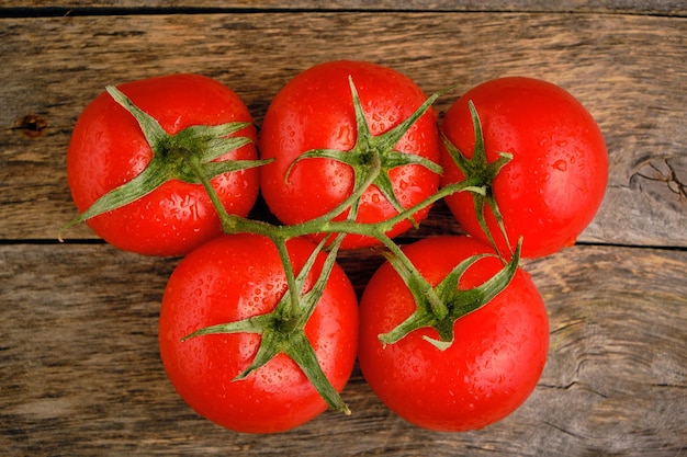 Tomates rojos maduros y brillantes fondo de madera