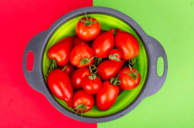 Tomates rojos maduros brillantes sobre fondo de color, banner, papel tapiz. Foto de estudio.