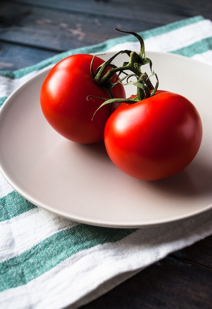 Tomates rojos maduros frescos en una rama