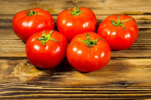 Tomates rojos maduros en mesa de madera