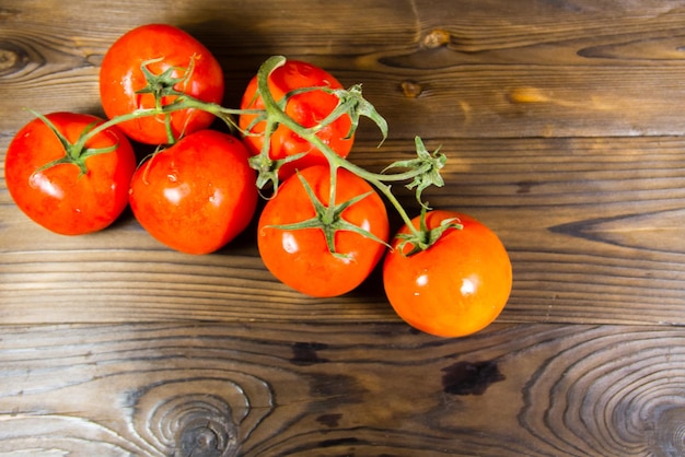 Tomates rojos maduros en mesa de madera