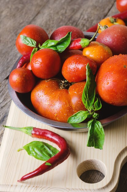 Tomates rojos maduros con pimientos y albahaca.