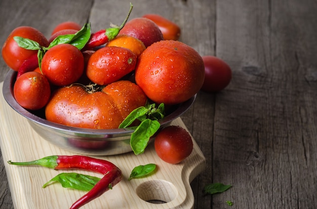 Tomates rojos maduros con pimientos y albahaca