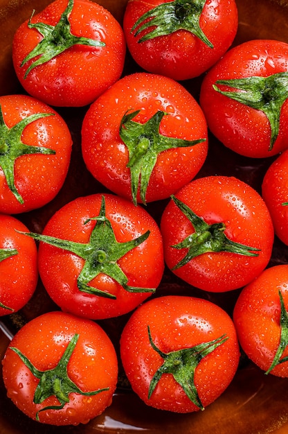 Tomates rojos maduros en placa rústica