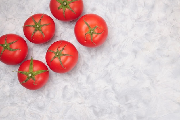 Tomates rojos maduros sobre una mesa de mármol