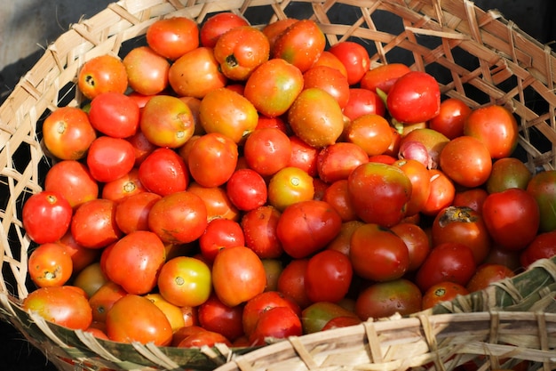 Tomates rojos en un mercado tradicional en una cesta de bambú