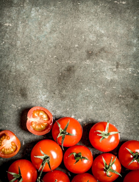 Tomates rojos mojados sobre la mesa de piedra.