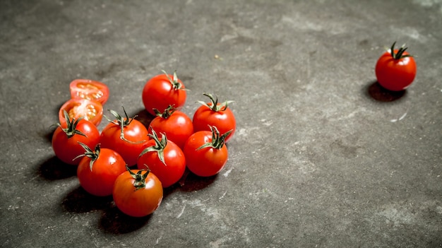 Tomates rojos mojados sobre la mesa de piedra.