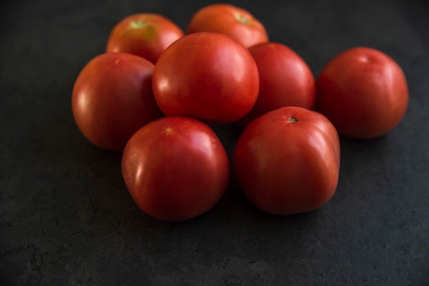 Tomates rojos en un mostrador de cocina oscuro