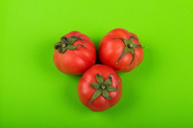 Tomates rojos sobre fondo verde