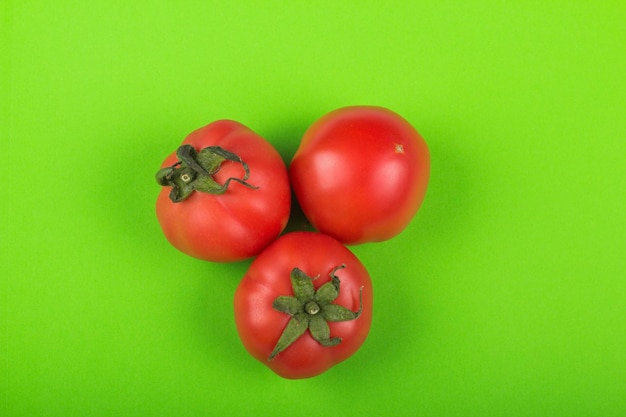 Tomates rojos sobre fondo verde