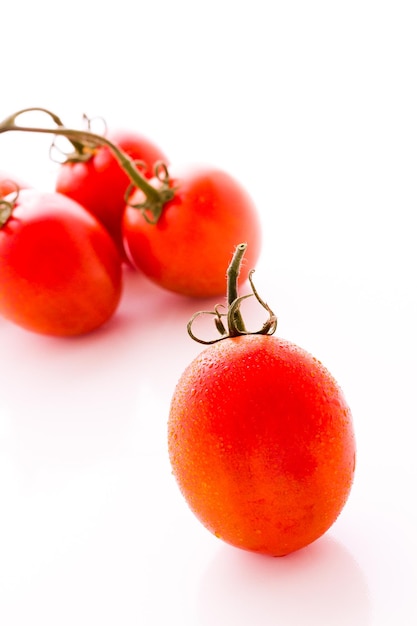 Tomates Roma orgânicos em fundo branco.