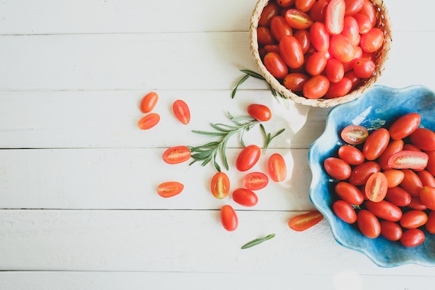 Tomates y romero frescos en un fondo blanco.