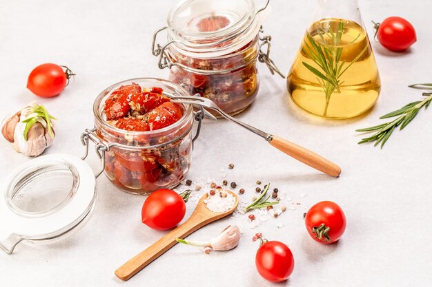 Tomates secados al sol con hierbas frescas y especias en aceite de oliva en un frasco de vidrio Antecedentes de recetas de alimentos. espacio para texto. vista superior.