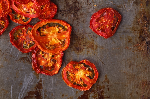 Tomates secados al sol sobre fondo rústico oscuro