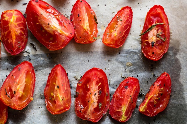 Tomates secados al sol sobre papel de horno blanco