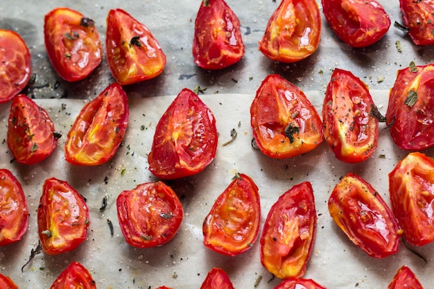 Tomates secados al sol sobre papel de horno blanco