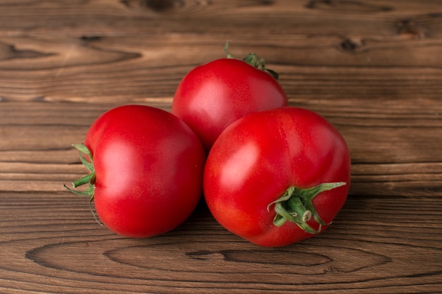 Tomates sobre fondo de madera