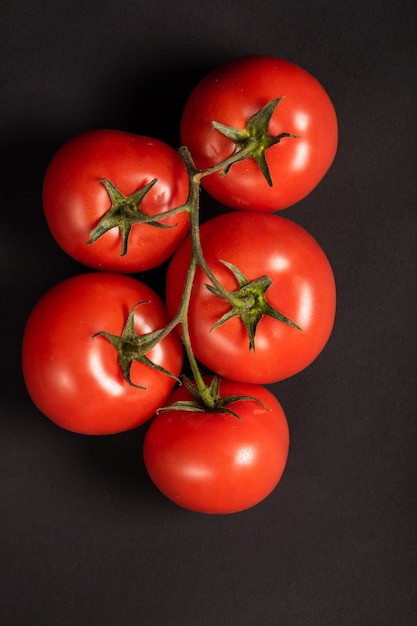 Tomates suculentos em uma superfície preta