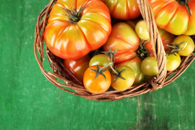 Tomates verdes en la cesta en la mesa de cerca