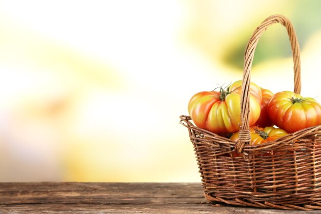 Tomates verdes en cesta sobre fondo brillante