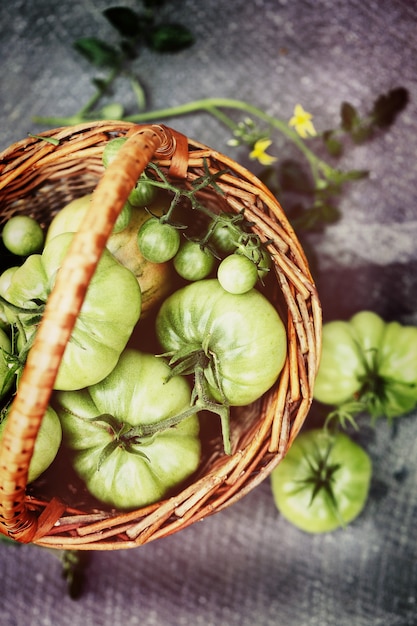 Tomates verdes e verdes em uma pequena cesta