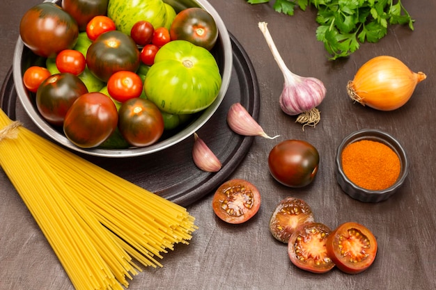 Tomates verdes e vermelhos na tigela Macarrão tomate picado cebola e alho na mesa