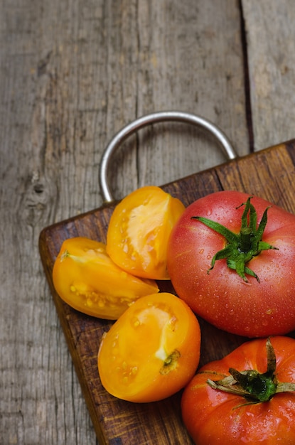 Tomates vermelhos e amarelos deliciosos em de madeira.